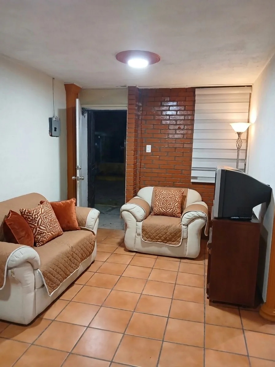 Sala amueblada con sillones y televisión